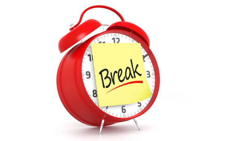 Red alarm clock with a yellow sticky note reading Break on a white background, suggesting a pause or reminder