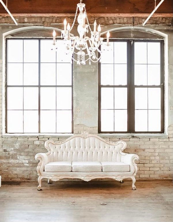 Indoor studio portrait setup in Minneapolis with brick wall backdrop and white couch, photographed by Black photographer