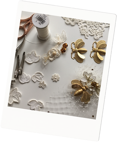 Closeup of gold bees, fabric, scissors and white cottn thread spool, in a polaroid frame