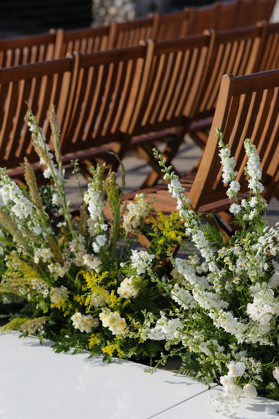 ceremony wooden chairs with floral aisle