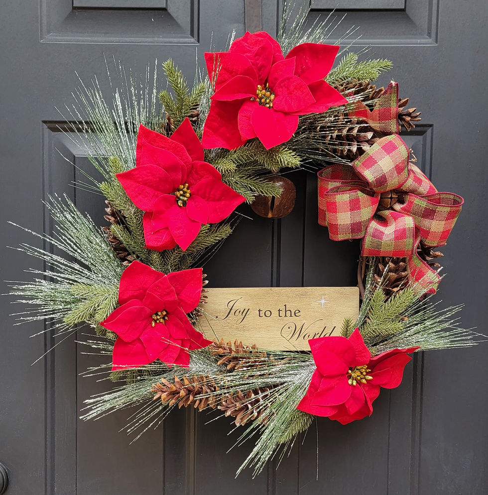 18" grapevine wreath adorned with 4 red poinsettias, snowy faux greenery, real pinecones and a "Joy to the World" sign.