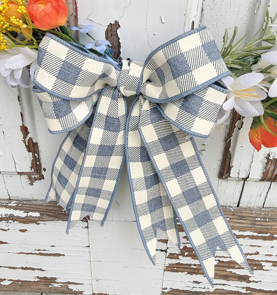 18" black wire hoop wreath base with delicate blue, white, yellow flowers on top of whispery greenery