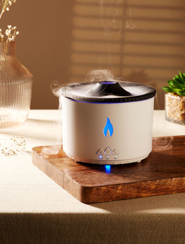 A White Volcano diffuser emitting white smoke in a creative lifestyle moodshot image by Bhumika Creatives Product Photography."