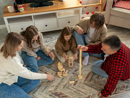 Family spending time indoors during winter, sitting on the living room floor and playing together, highlighting indoor air quality in indoor spaces where clean indoor air and proper ventilation affect human health.