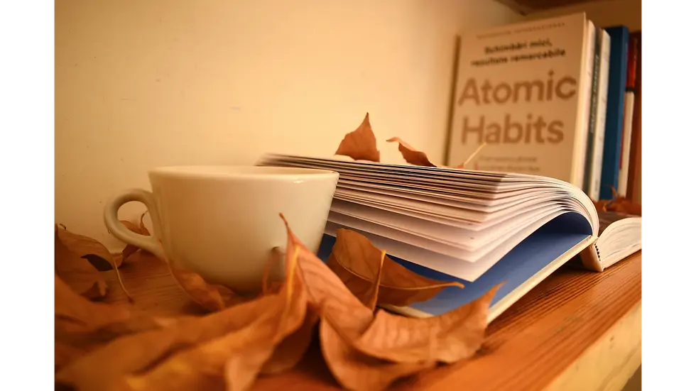 Cozy reading nook with coffee, open book, and autumn leaves beside a guide to habits backed by science