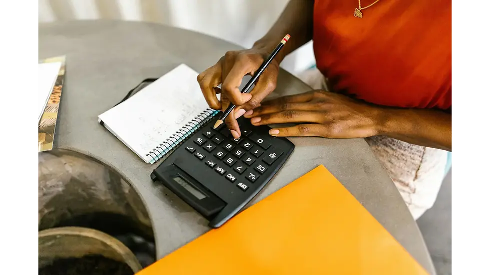 Close-up of a young person budgeting personal finances in a notebook with a calculator.