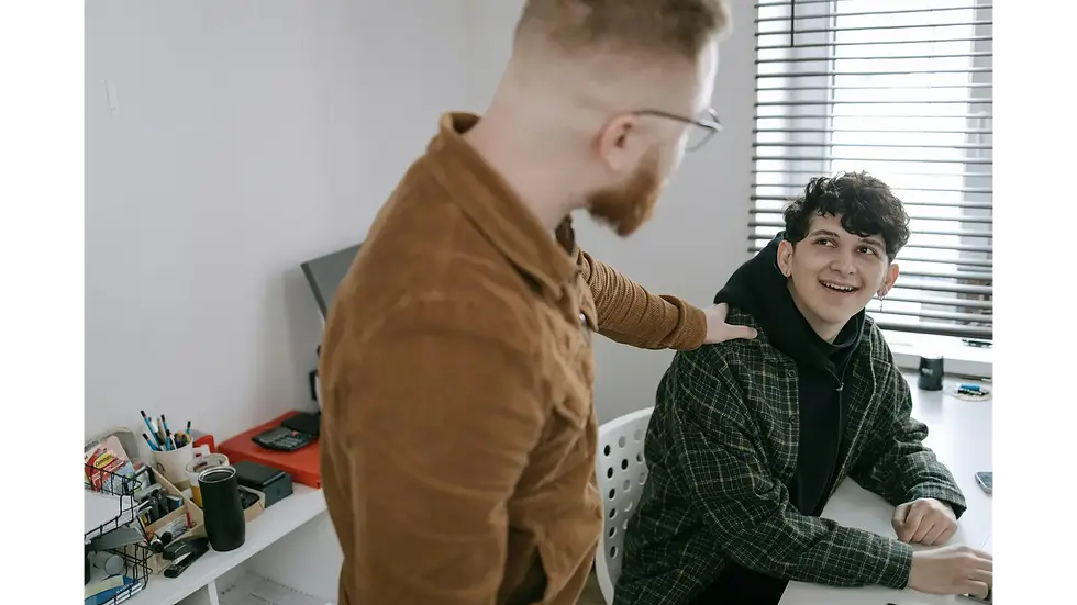 A coworker places a supportive hand on a colleague's shoulder to help them avoid stress and severe burnout at work.