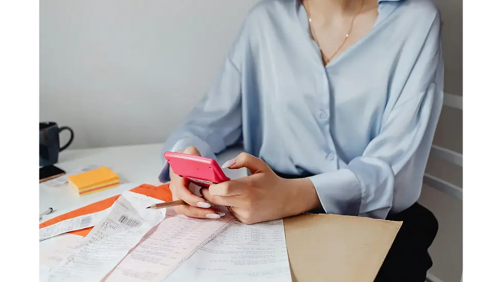 Woman using a calculator and receipts at a desk, showing budgeting methods for tracking expenses and planning finances