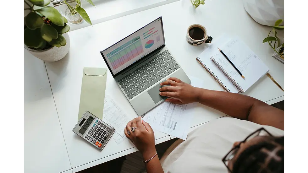 Person reviewing expenses on a laptop and calculator, showing how your salary budget can stay organized