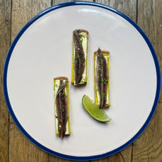 Toast de pain de mie au curcuma, beurre doux, anchois, zeste de citron vert