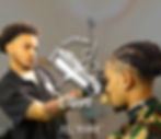 A skilled barber, Cutts By Clipps, focuses intently while crafting a stylish and precise haircut for a client, showcasing expertise and attention to detail.