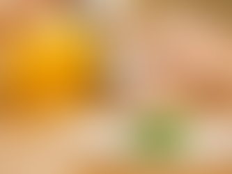 A person in yellow focuses on a fork above a tiny piece of kale on a white plate. The mood is contemplative.
