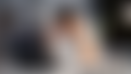 Man in white shirt holds head in frustration at desk with laptop. Papers and pen holder nearby. Office setting, muted colors, tense mood.