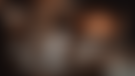 Cozy scene of a person in knitwear reading by a crackling fireplace. Soft focus, warm tones create a tranquil, relaxed atmosphere.