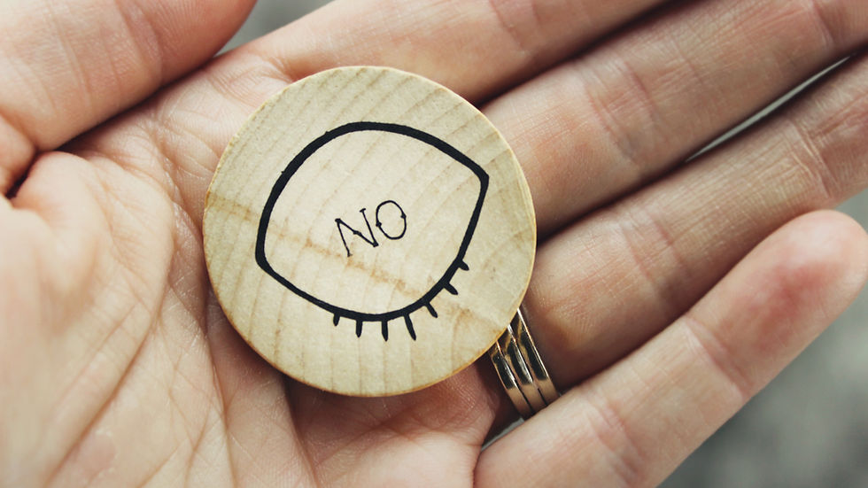 A hand holding a button that says no.