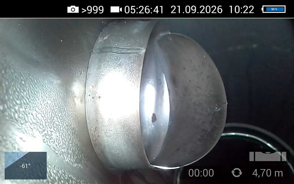 Close-up van metalen pijp in donkere schacht, met reflecties en inspectie