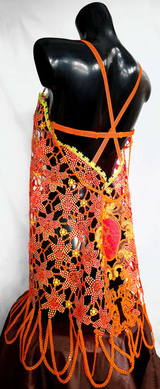 Three-quarter view of a fully 3D-printed slip dress showing crochet-inspired hibiscus lace, modular orange strap harness, ornate scenery back panel, and PLA looped fringe hem on a black mannequin.