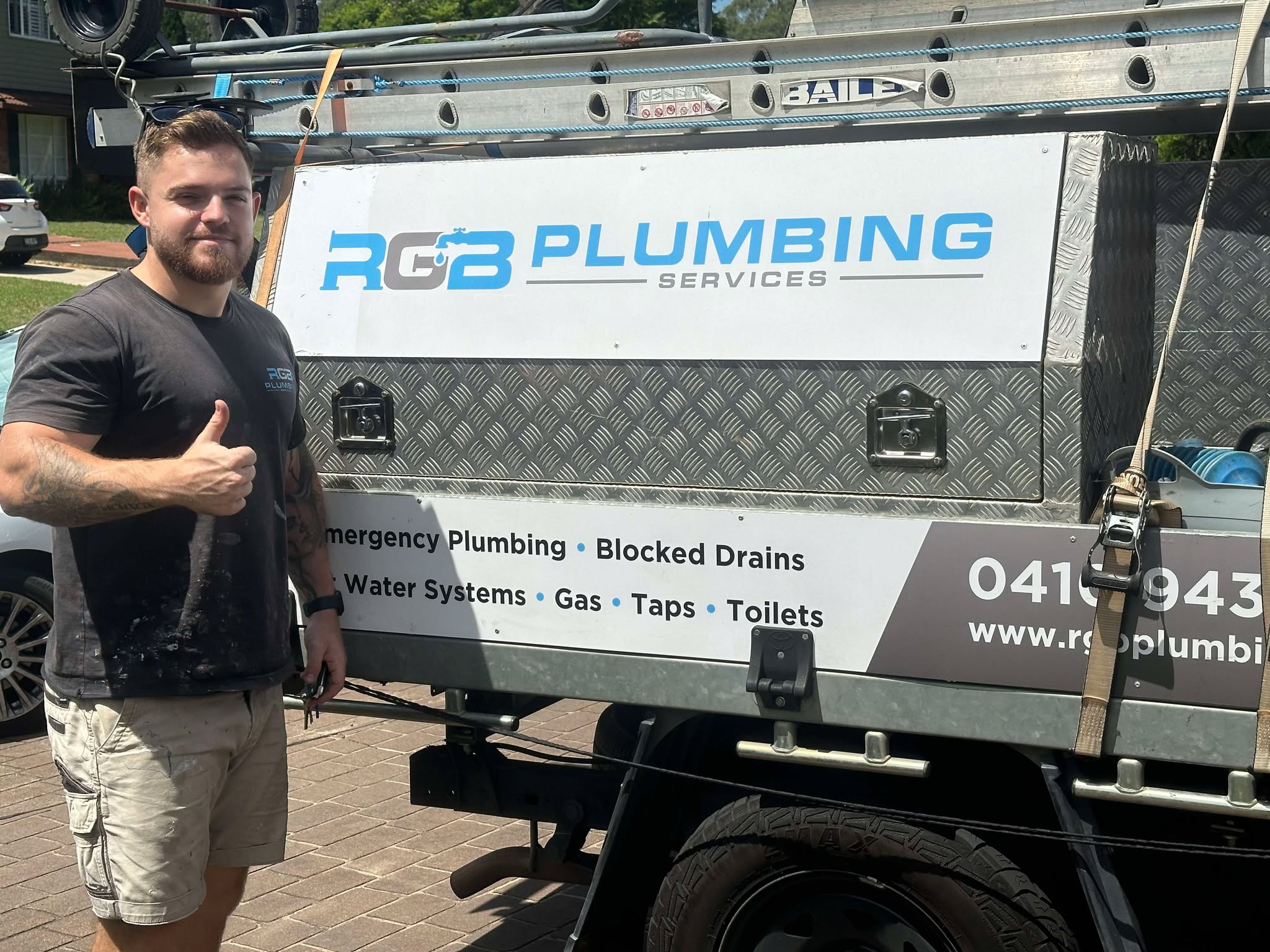 Rhys from RGB Plumbing standing in front of work ute in Quakers Hill