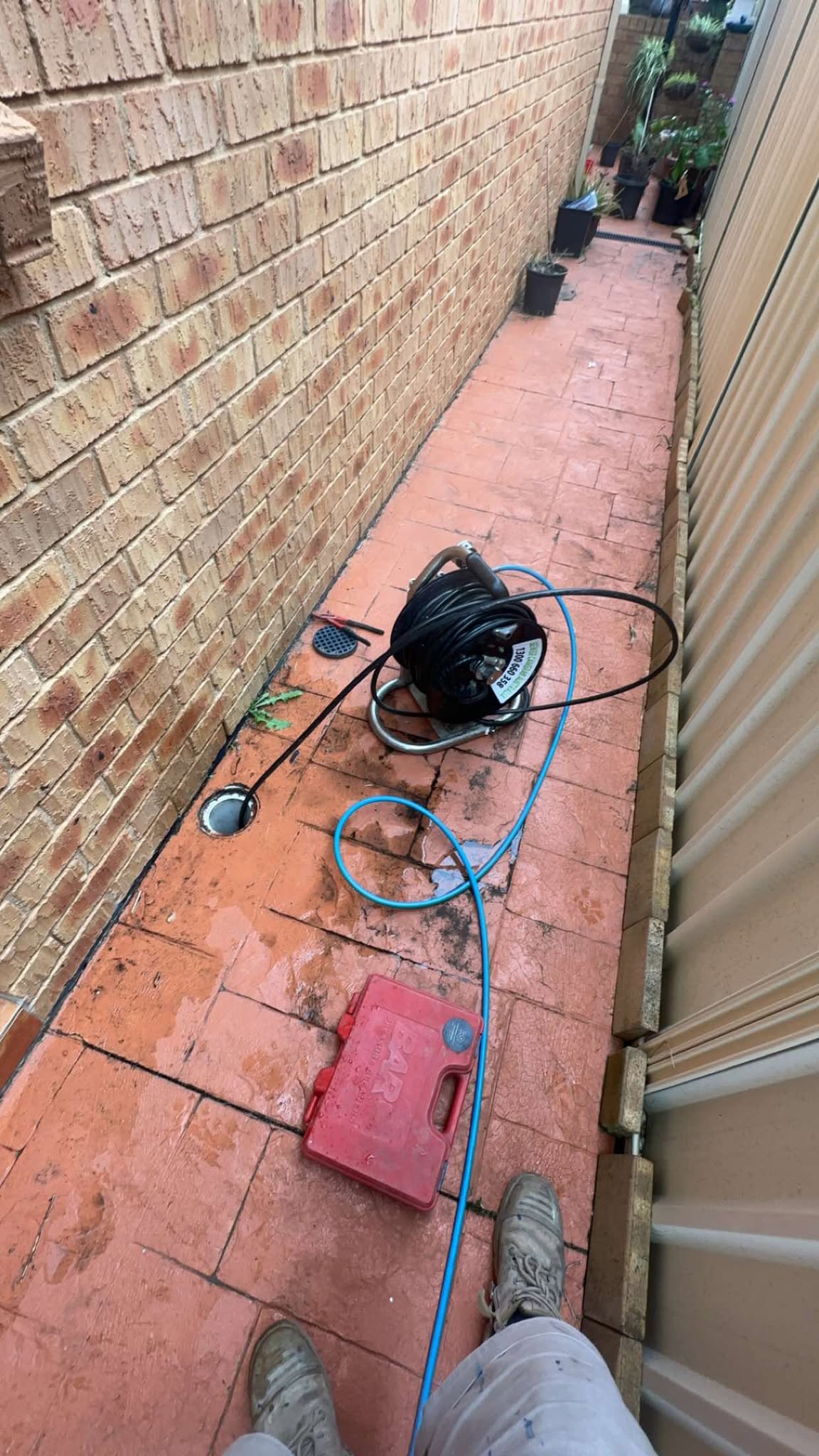 Drain plumber inspecting sewer blockage repair