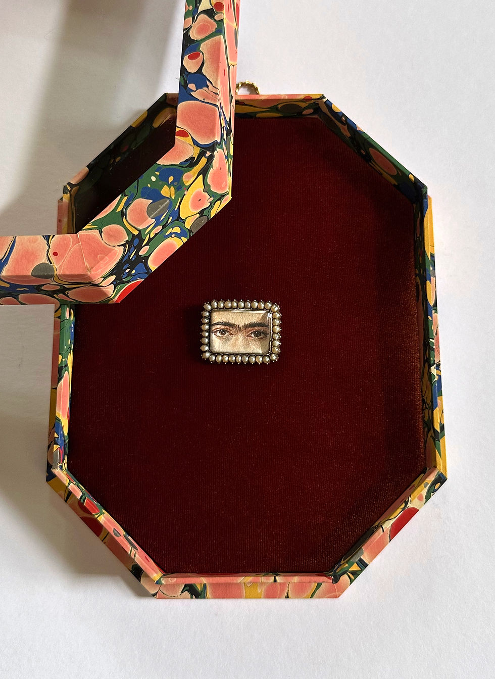An artist's eye brooch in a bespoke shadow box