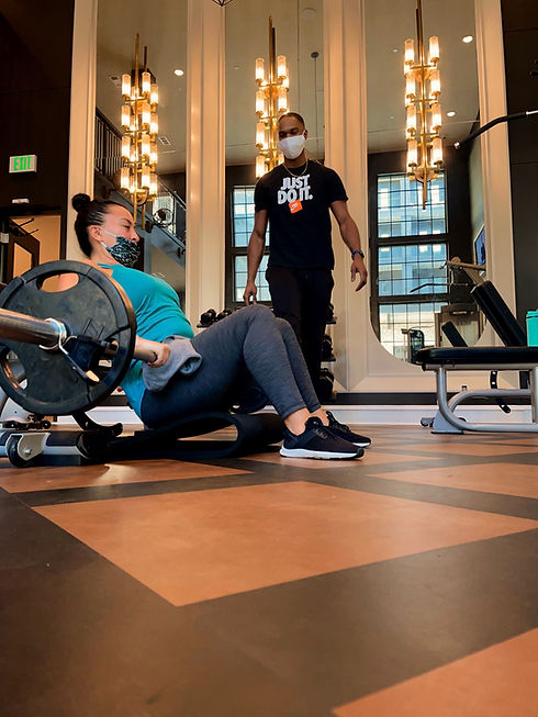 Man training women on weight machine