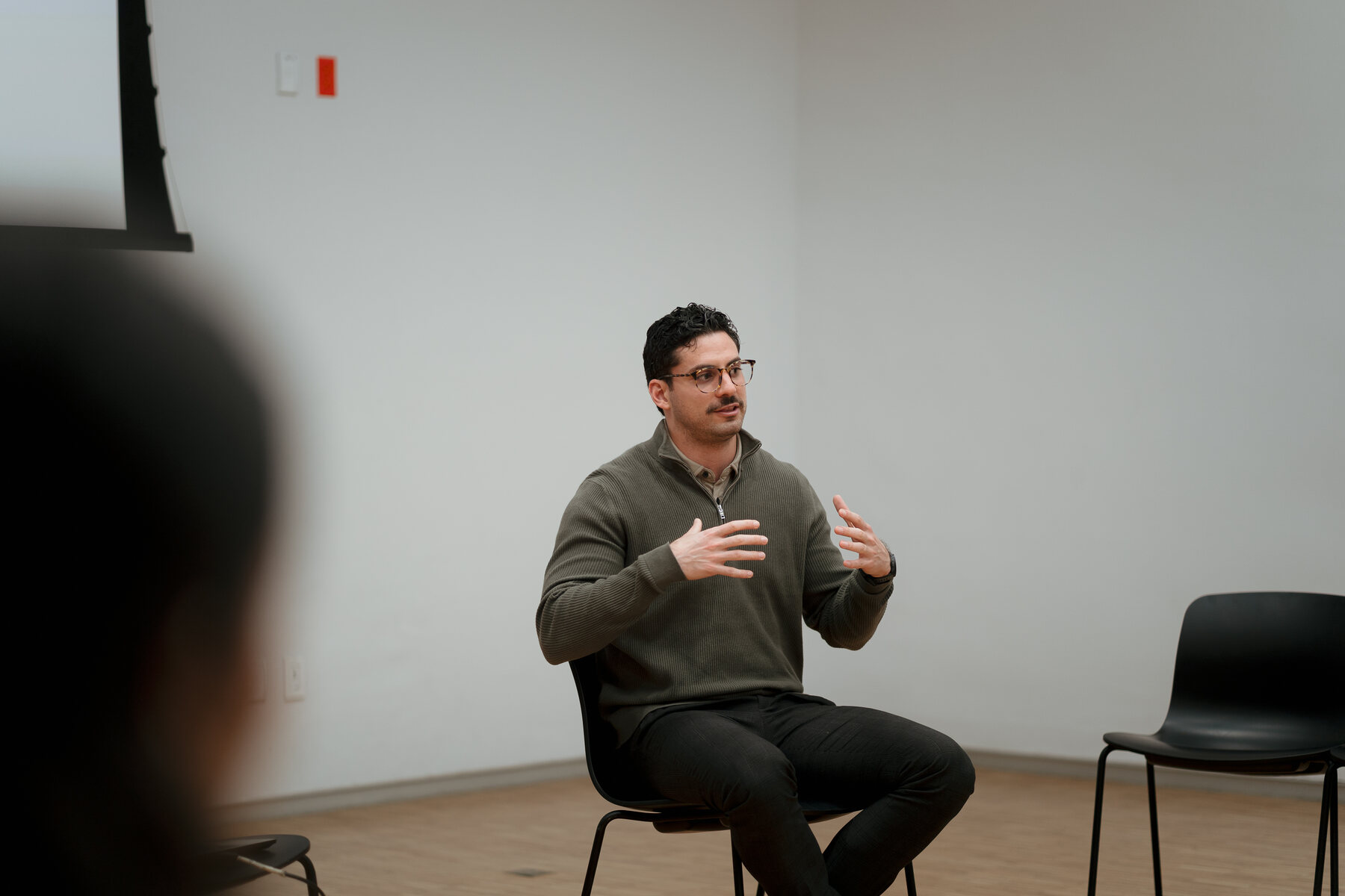 Rodrigo sentado conversando con un grupo