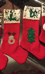 Handmade cotton Christmas stocking personalised with a name, featuring festive fabric and stitched detailing