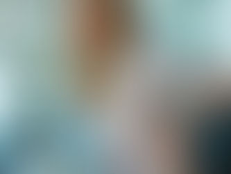 a middle aged lady with blonde hair leans forward in her chair in discomfort due to living with degenerative disc disease