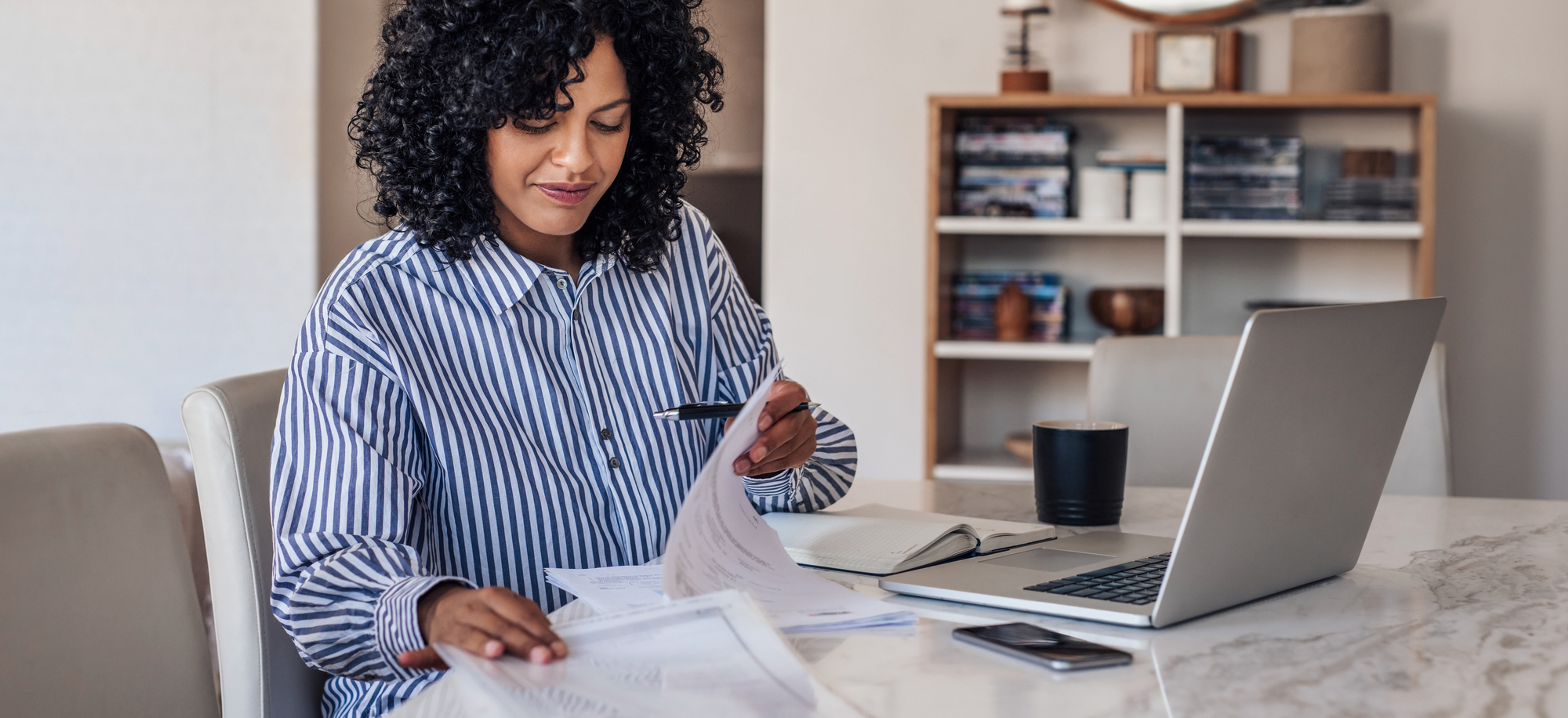 Employee working from home with paperwork and a laptop, relevant to Victoria's new work from home law.