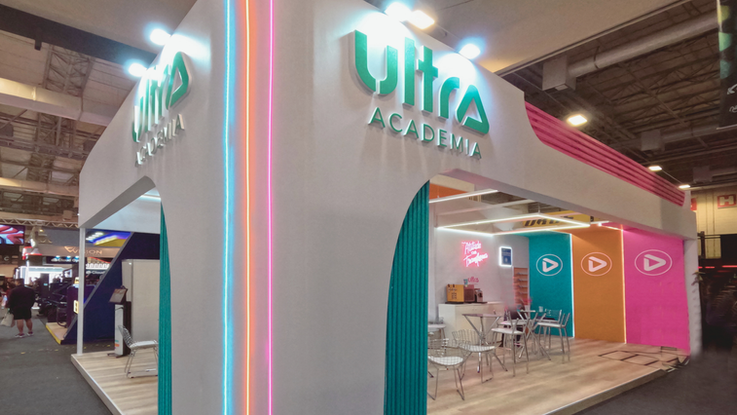 Estande Ultra Academia com portais coloridos e neon na IHRSA Fitness Brasil, montagem MODU