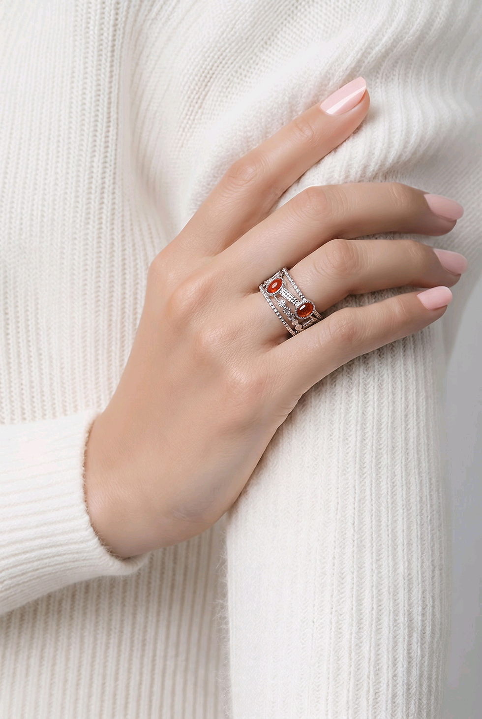 Main portant une bague entrelacée rouge et argentée.