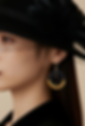 Boucles d'oreilles coeurs suspendus portées avec chapeau noir