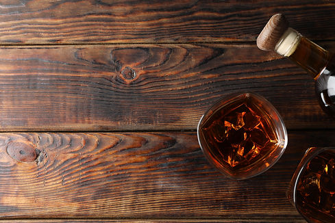vecteezy_bottle-and-glasses-of-whiskey-on-wooden-background-top-view_73823665.jpg