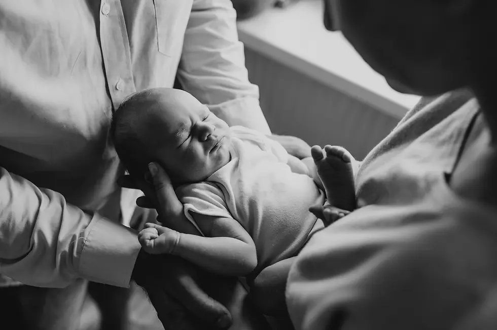 Noworodek w objęciach rodziców  - sesja noworodkowa lifestyle Warszawa