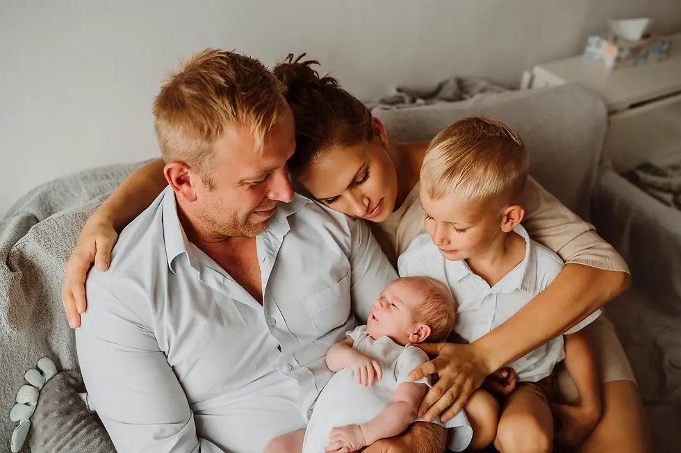 Rodzina w objęciach podczas sesji noworodkowej w domu Warszawa