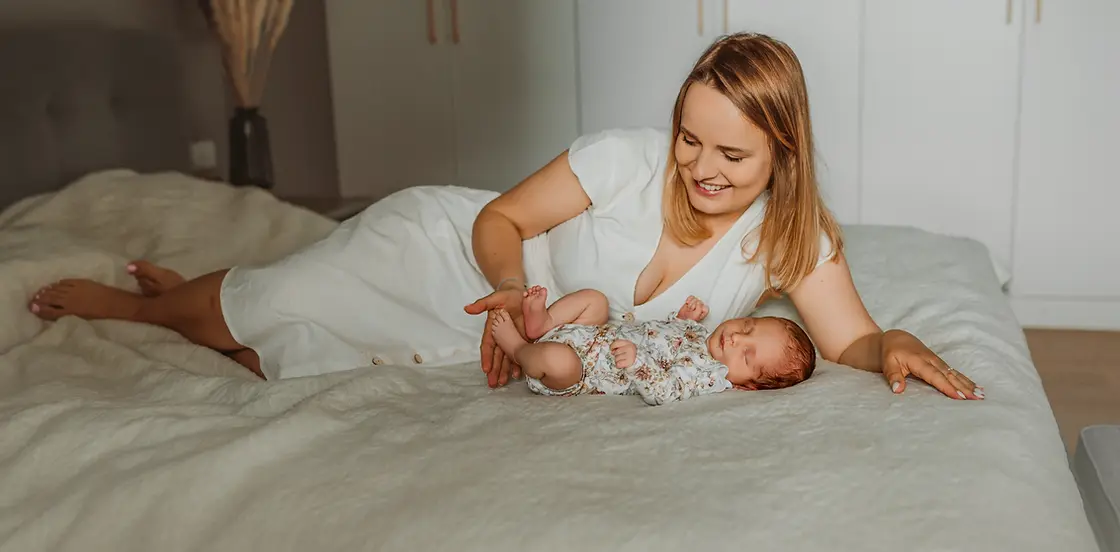 Naturalna sesja noworodkowa w domu Warszawa - mama z noworodkiem na łóżku