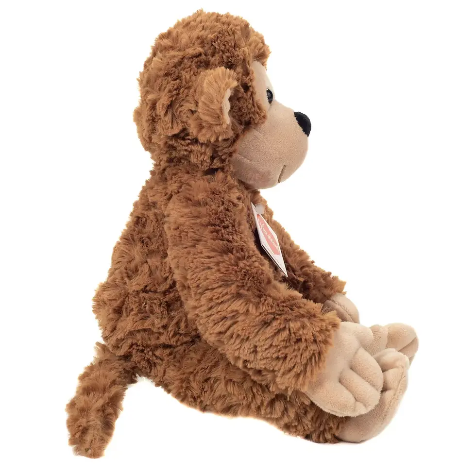 Miniature : Peluche singe brun vue de profil, montrant sa fourrure frisée et sa queue souple