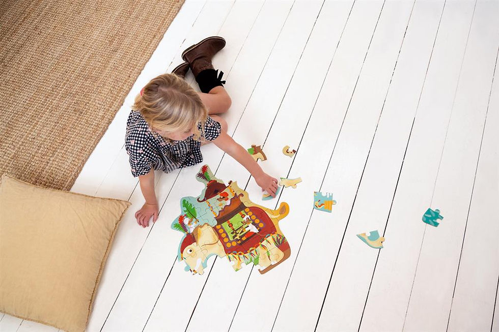 Miniature : Enfant jouant avec un puzzle éléphant sur un sol blanc, pièces éparpillées autour