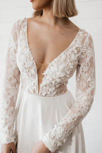 Cizzy Bridal Lace Long Sleeve Wedding Dress with cut outs. Backless style with flowing a-line skirt and wedding dress train.