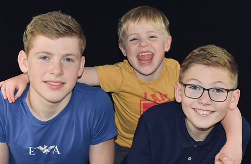 Three boys, embracing and smiling
