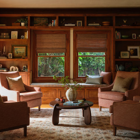 Cozy living room with armchairs and wooden shelves.