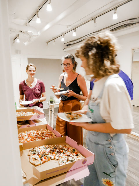 four people eating pizza
