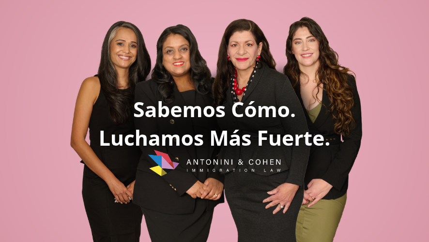 Las abogadas de inmigración Sonal Shah, Nisha Karnani, Carolina Antonini y Kathleen Hoyos, vestidas con trajes de negocios negros, posan sobre un fondo rosa con el lema "Sabemos cómo. Luchamos más duro". Antonini & Cohen Immigration Law