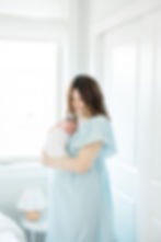 Newborn photographers Philadelphia - melissa joy photography - new mom standing wearing light blue dress while holding newborn baby on her chest
