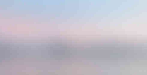 Morze, w tle płaskie ośnieżone góry, różowe niebo