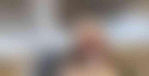 Kobieta w puchowej kurtce na tle wodospadu