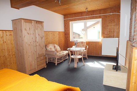 Gesamtansicht des Zimmers Caprimond mit Sitzecke und Kleiderschrank