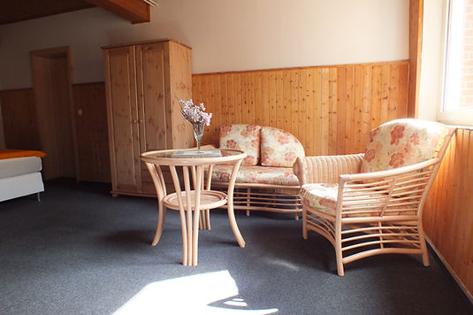 Sitzecke mit Korbmöbeln im Zimmer Caprimond