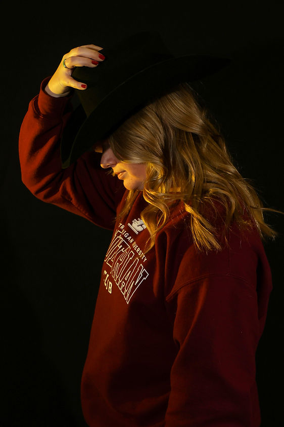 Central Michigan University junior Jenna Hubert poses for a sportrait themed picture in Moore Hall, Tuesday, December 2, 2025. Hubert is CMU equestrian stock captain qualifying for the 2024-25 regionals in Midland. Camera settings: 1/250, 55mm lens, f/5.6, ISO 800. Flashes A,B,C 1/64.