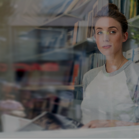 Woman looking out the street through a plain window without any privacy in the reading room